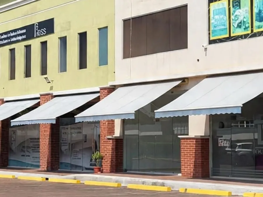 Locales comerciales con toldos blancos y columnas de ladrillo