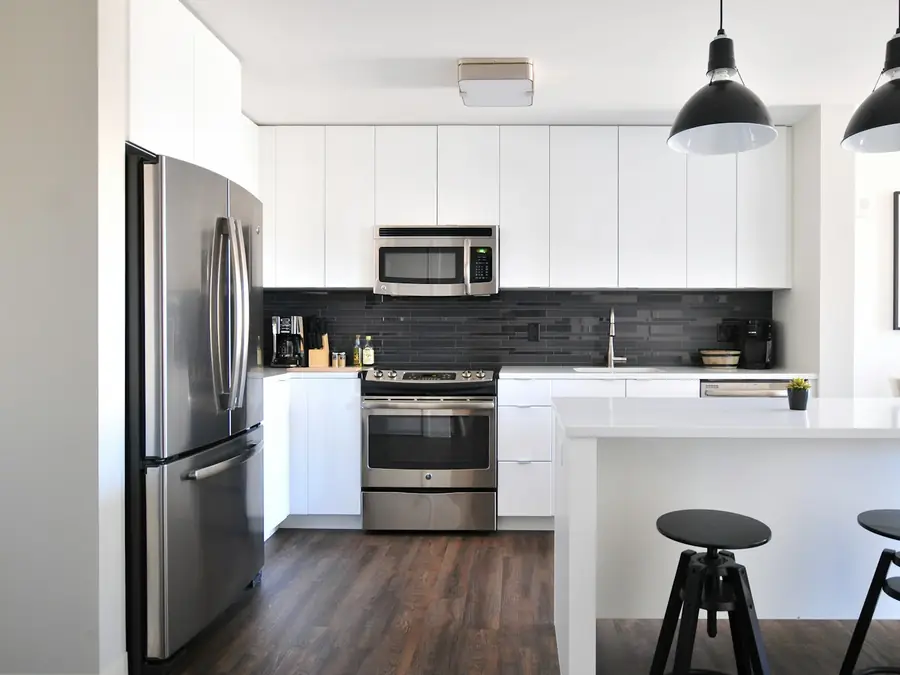 Cocina con muebles blancos y mesón renovado