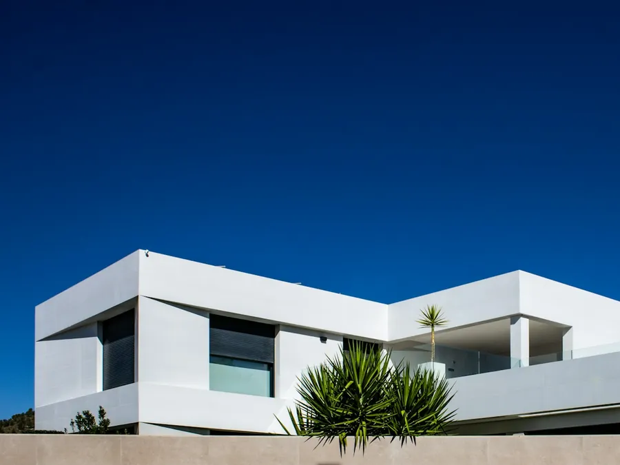 Fachada moderna de una vivienda pintada de blanco contra el cielo azul