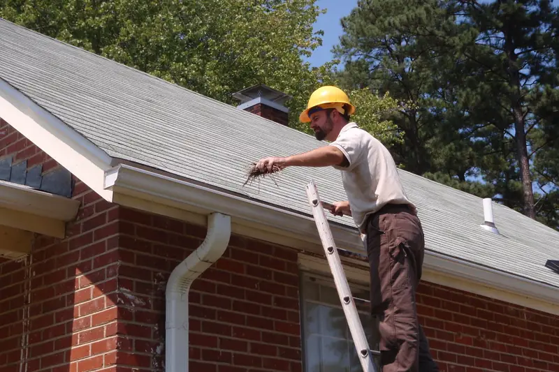 Técnico con casco limpiando las canaletas del techo de una vivienda